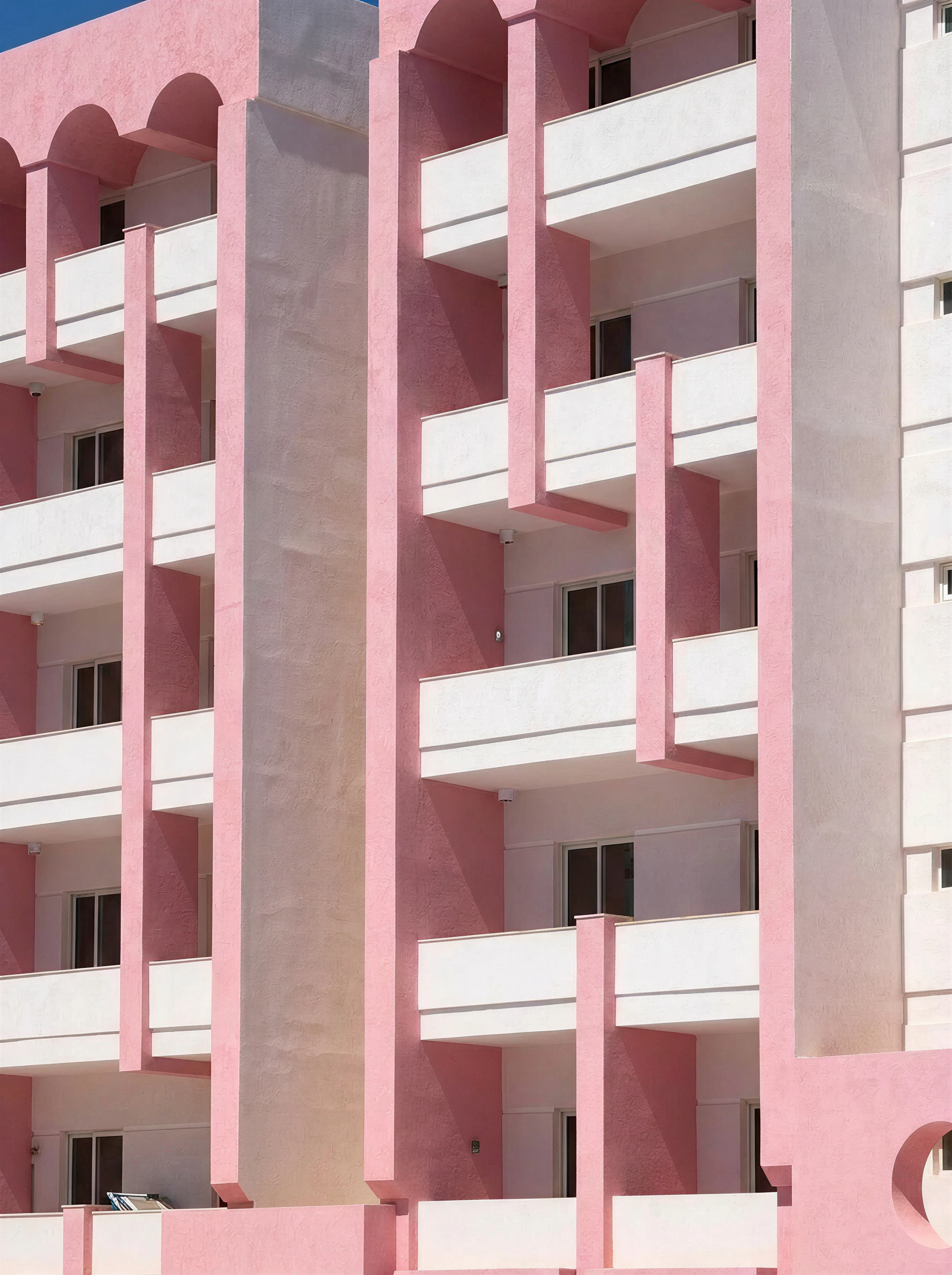 Pink arched balconies on The Flamingo Apartments building exterior, Malta