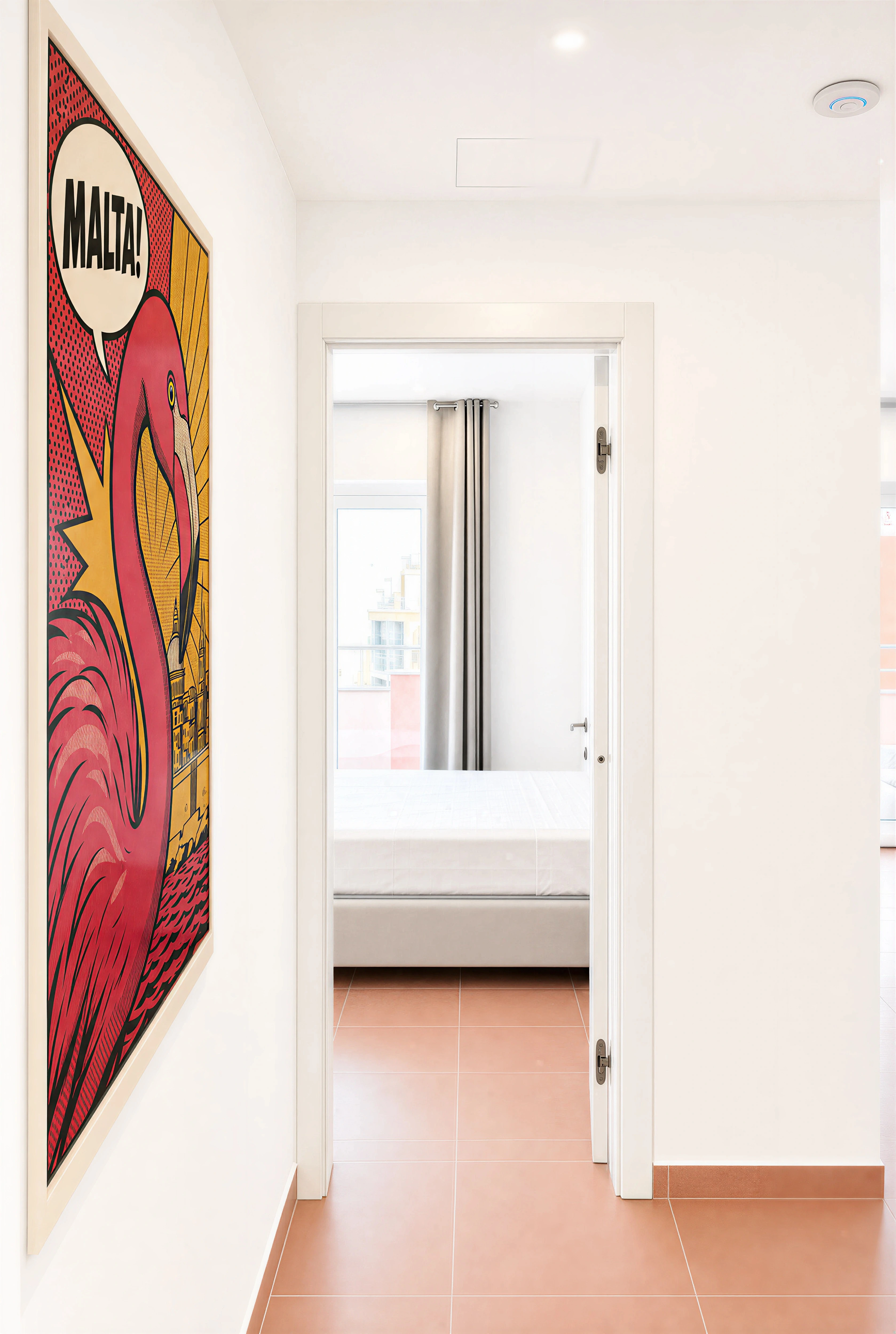 Entry hallway with "MALTA!" flamingo pop-art poster in a 3-bedroom Flamingo apartment, Paceville
