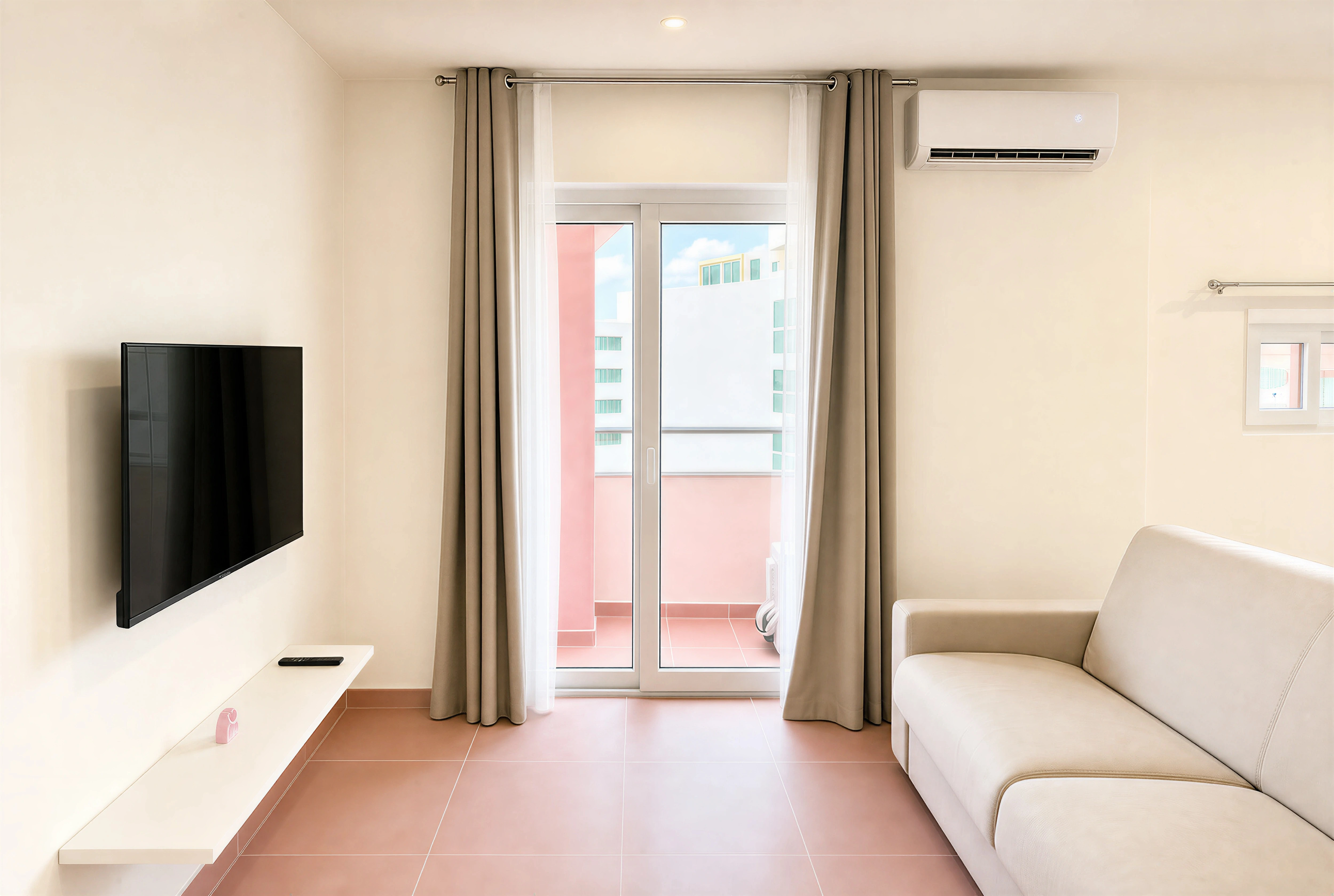 Cosy TV lounge with sheer voile curtains and balcony doors at The Flamingo Apartments