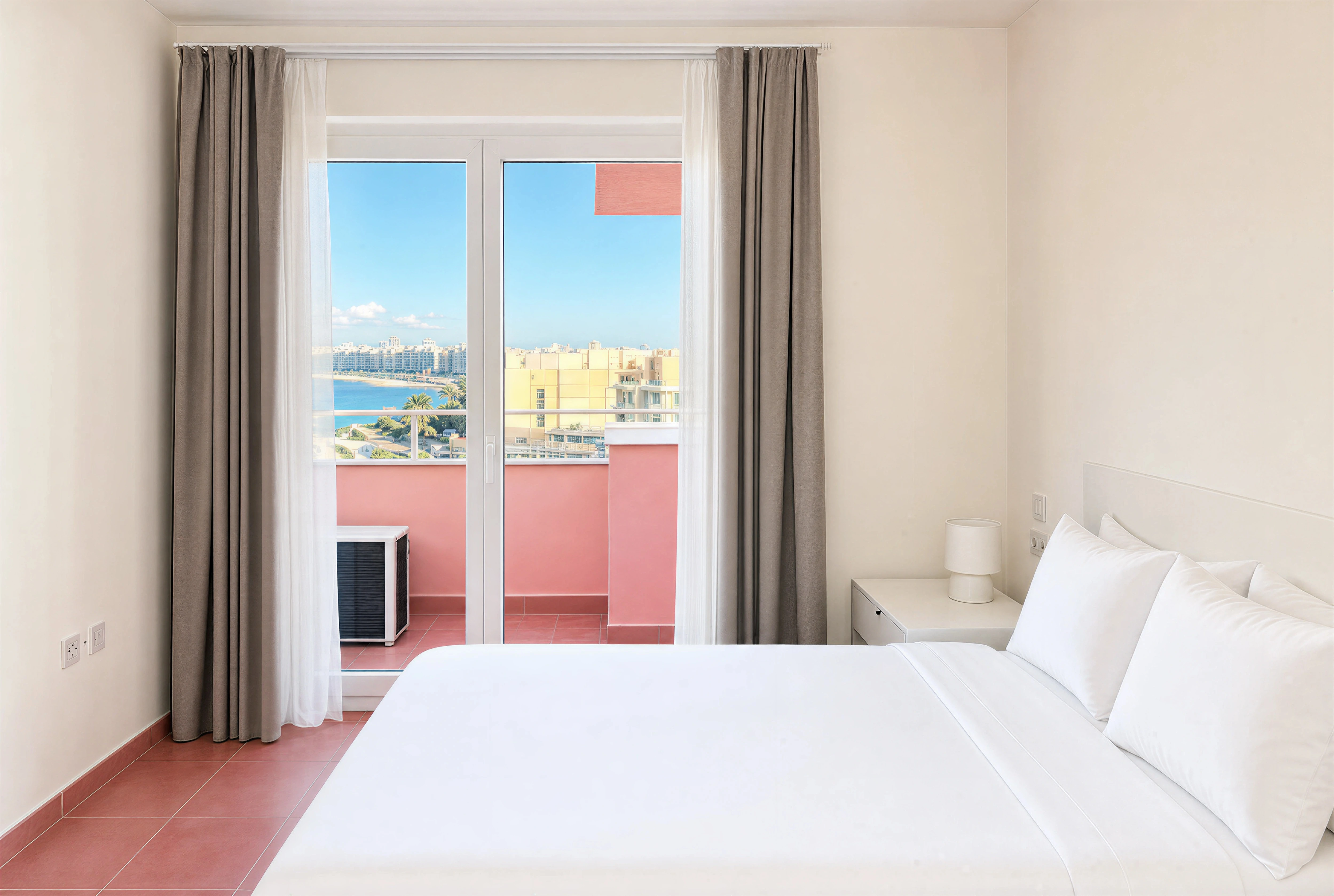 Master bedroom with French doors opening onto a pink balcony and Sliema sea view