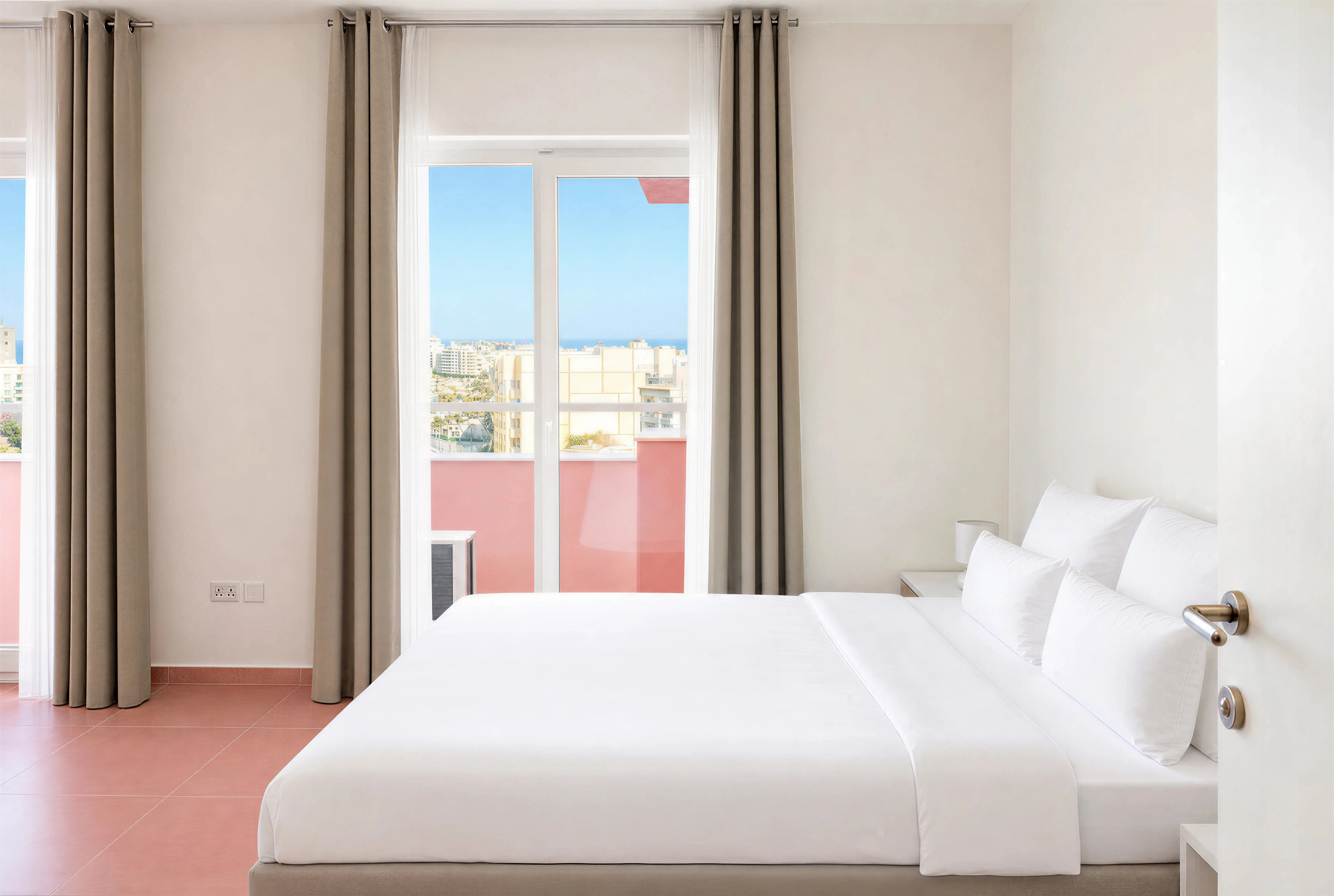 Master bedroom with double bed and balcony doors at The Flamingo Apartments Paceville