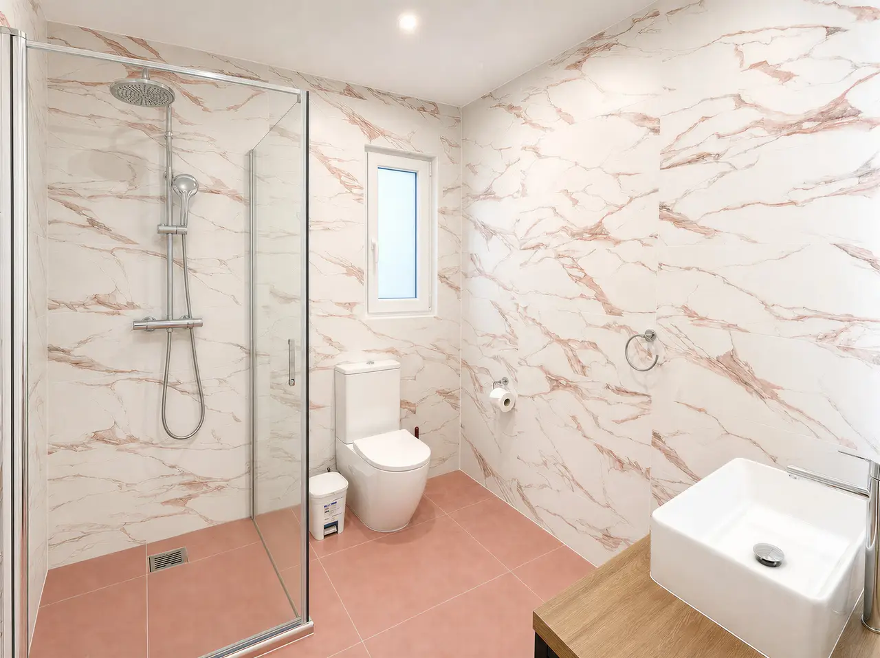 Bathroom with a walk-in glass shower, toilet, basin and pink-veined tiles